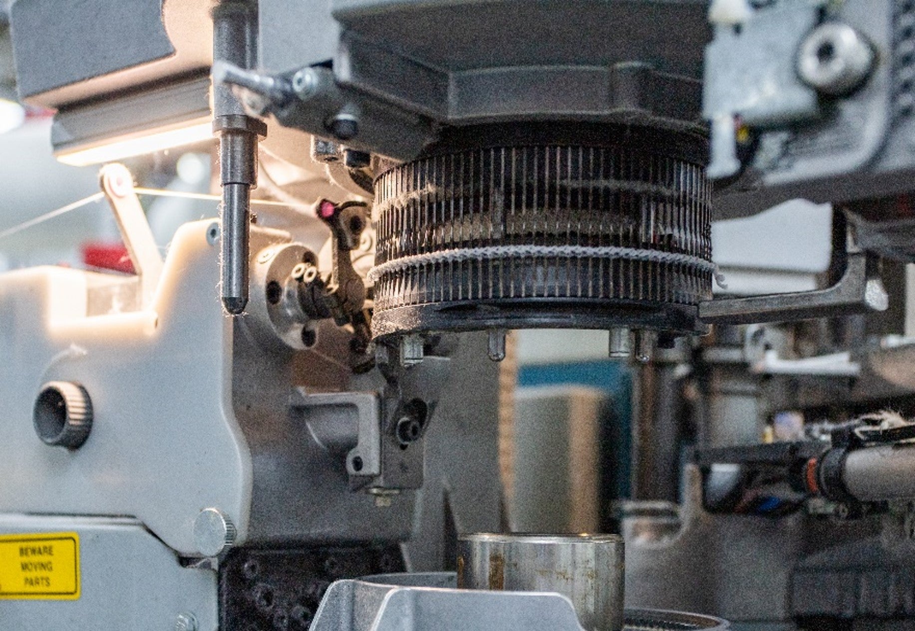 Close up photo of a knitting machine creating a seamless toe closure.